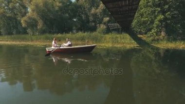 Gelin ve damat ağaç kaplama ve buna göle yüzen bir beyaz tekne oturan Üstten Görünüm