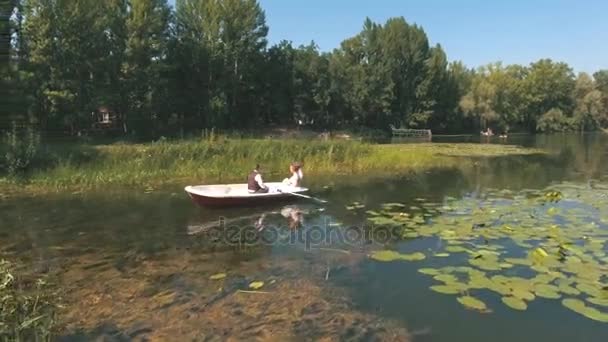 Bovenaanzicht op paar is drijvend op een boot op het meer in hout — Stockvideo