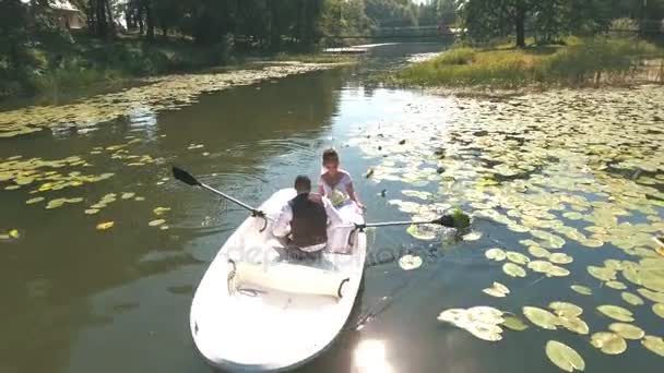 Vista superior no casal está flutuando em um barco no lago em madeira — Vídeo de Stock