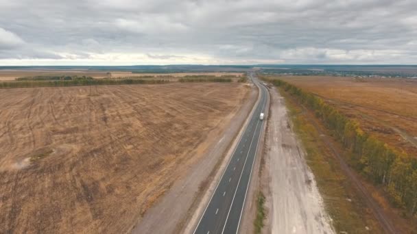 Uitzicht over de vroege herfst velden en een dual rijbanen weg vanuit de lucht — Stockvideo