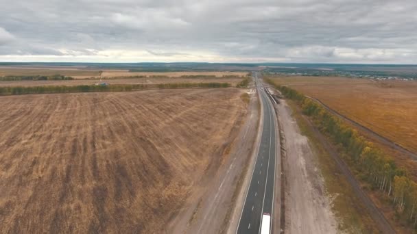 Uitzicht over de vroege herfst velden en een dual rijbanen weg vanuit de lucht — Stockvideo