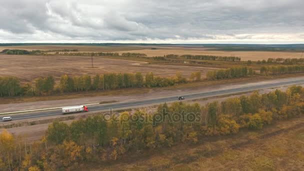 Uitzicht over de vroege herfst velden en een dual rijbanen weg vanuit de lucht — Stockvideo