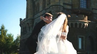 Güzel genç gelin ve yakışıklı damat açık havada eski mansion yakınındaki havadaki holding
