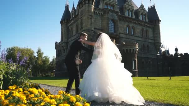 Bella giovane sposa e bello sposo tenuta in aria all'aperto vicino vecchia villa — Video Stock