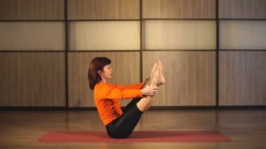 bir kadın germek için egzersizler gerçekleştirir