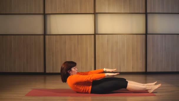 Instructora femenina haciendo ejercicios de pilates de estiramiento en el club deportivo — Vídeos de Stock