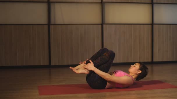 Femeia de vârstă mijlocie care practică yoga — Videoclip de stoc