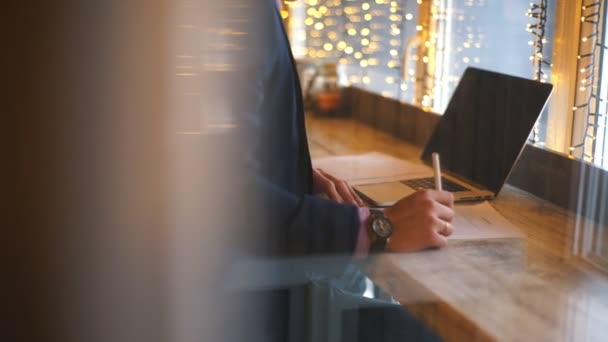 Un joven empresario se sienta en una cafetería y estudia el contrato — Vídeo de stock