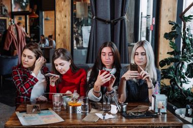 Kafede bir masada oturmuş kahve dört şık genç kadınla