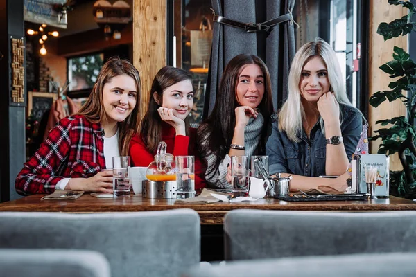 Quatre amis dans le café regarder la caméra et rire — Photo