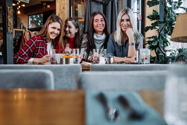 Cuatro amigos en el café miran a la cámara y se ríen —  Fotos de Stock