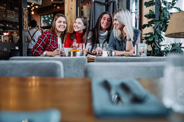 Quatro amigos no café olham para a câmera e riem — Fotografia de Stock