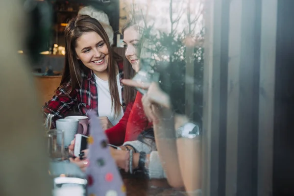 Dos hermosas mujeres tomando café y charlando en la cafetería —  Fotos de Stock