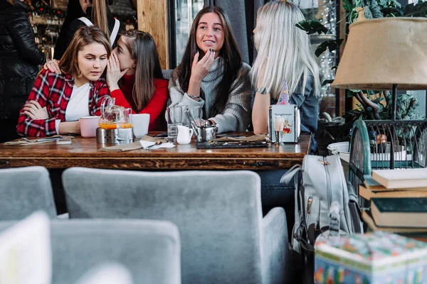Quatre amis bavardant dans un café — Photo