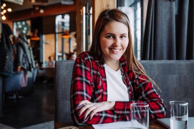 kafede oturan kamera gülümseyen güzel esmer