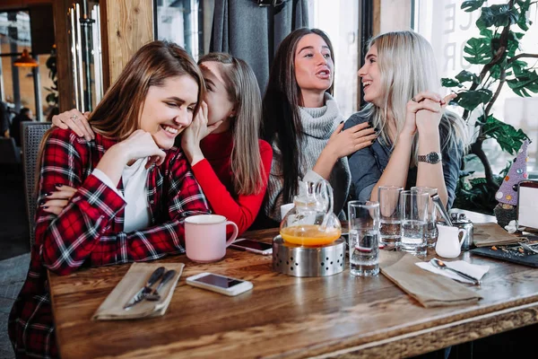 Fyra vänner skvallra på ett café — Stockfoto