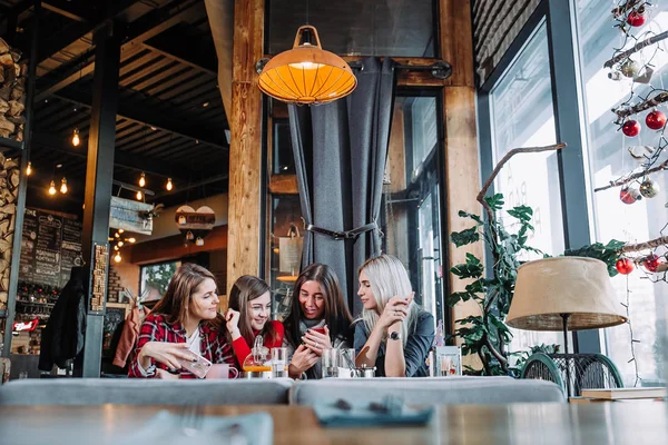 Fyra vänner sitter i tabellen i café och göra selfie på smartphone — Stockfoto