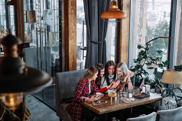 Quatre amis regardent le téléphone et rient — Photo