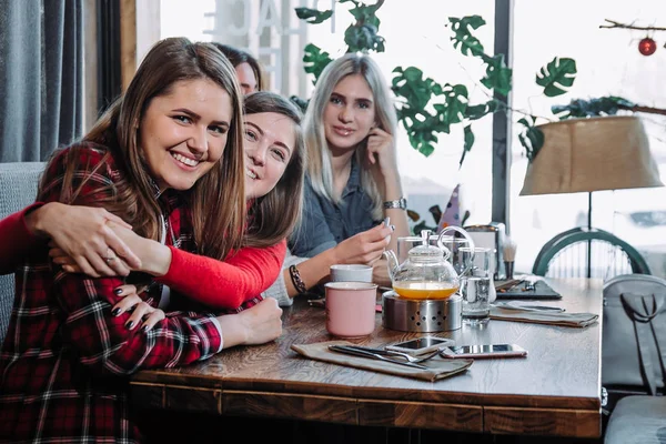 Fyra vänner i café titta på kameran och skratt — Stockfoto