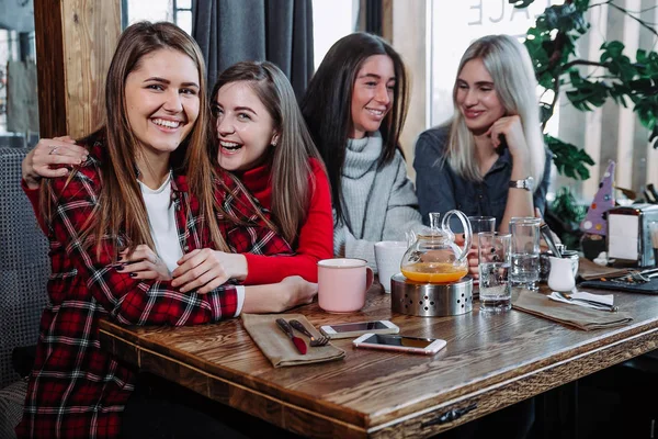 Cuatro amigos en el café miran a la cámara y se ríen —  Fotos de Stock