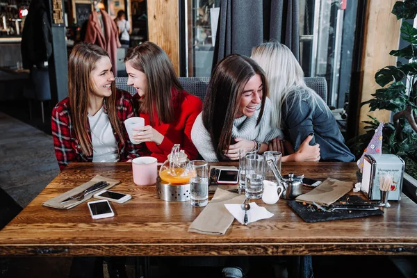 Quatre amis dans le café regarder la caméra et rire — Photo