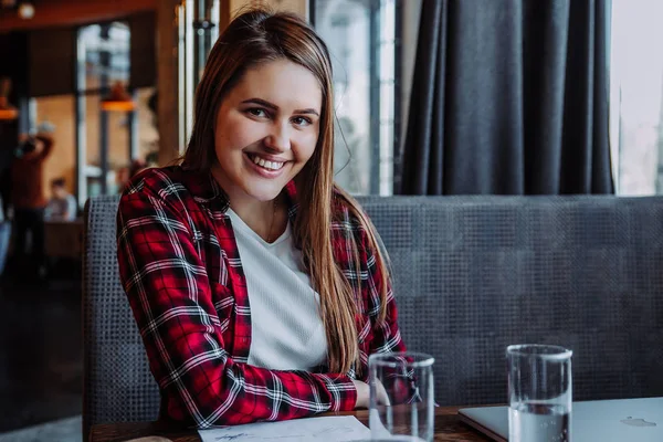 Schöne Brünette lächelt vor laufender Kamera im Café — Stockfoto