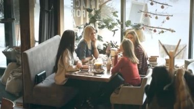 Grup dört genç insan Restoran masada oturma ve yemek sırasında eğlenmek.