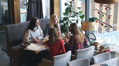 Grup dört genç insan Restoran masada oturma ve yemek sırasında eğlenmek.