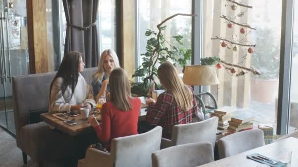 Четыре подруги наслаждаются разговорами в кафе — стоковое видео