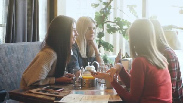 Vier vrienden kijken naar de telefoon en lach — Stockvideo