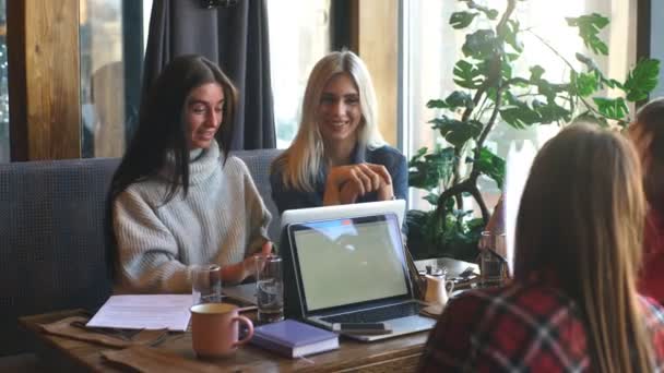 Fyra vackra affärskvinnor som arbetar på ett kafé med en bärbar dator — Stockvideo