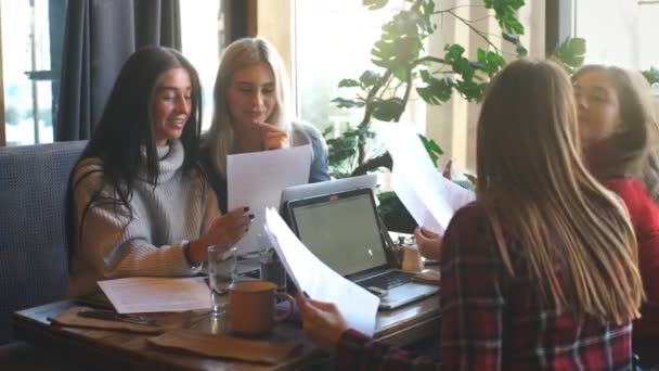 Atractivo dos mujer de negocios discutiendo documento y el uso de un ordenador portátil en la cafetería — Vídeos de Stock