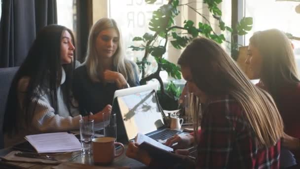 Hermosa mujer de negocios discutiendo documentos en un café sobre una taza de café — Vídeos de Stock