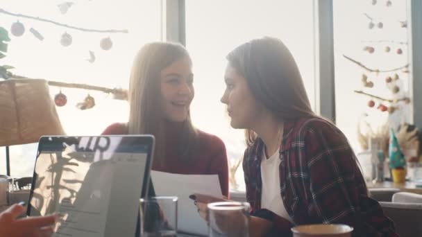 Twee vrouwelijke ondernemers in een café bespreken contracten en documenten tijdens de lunch — Stockvideo