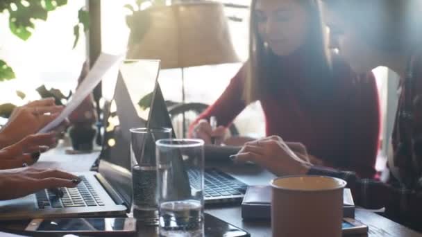 Dos mujeres de negocios escribiendo en un ordenador portátil en un café — Vídeos de Stock