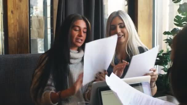 Две деловые женщины, работающие вместе над документами, партнеры обсуждают план или идею и мнение встречи — стоковое видео