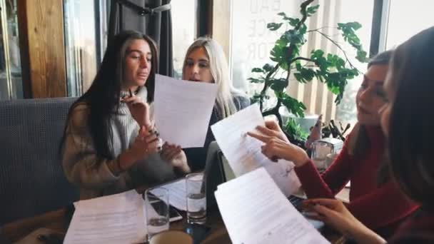 Ett företag affärskvinnor aktivt diskuterar ett affärsprojekt i ett café — Stockvideo
