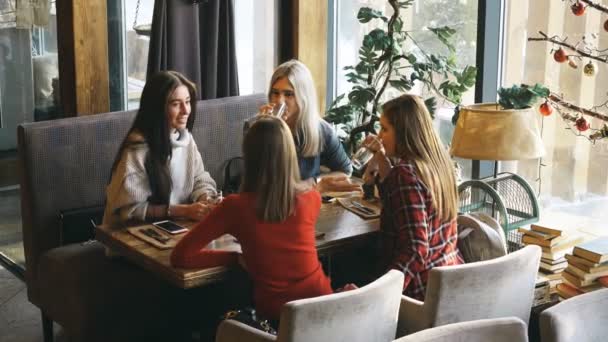 Cuatro amigos desayunan en un café y se comunican — Vídeo de stock