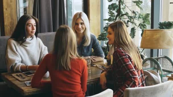 Vier vrienden ontbijten in een café en communiceren — Stockvideo