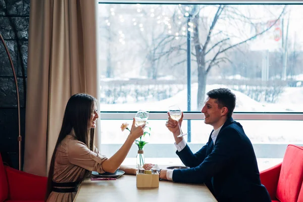 Coppia sorridente che cena e beve vino bianco all'appuntamento nel ristorante — Foto Stock