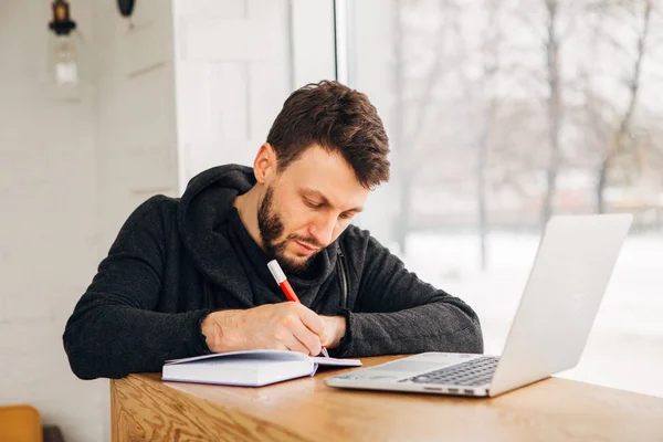 Bir çevirmen bir dizüstü bilgisayar ile bir not bir not defterinde yazıyor. — Stok fotoğraf