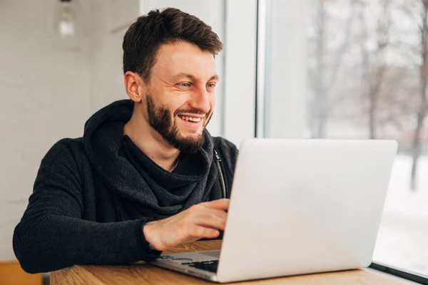 Mutlu genç öğrenci diploma projesi üzerinde çalışırken genel dizüstü bilgisayar klavye üzerinde ellerini tutarak sakallı — Stok fotoğraf