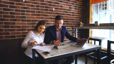 Kafede dizüstü bilgisayar üzerinde çalışan iki genç iş adamları