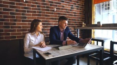 Kafede dizüstü bilgisayar üzerinde çalışan iki genç iş adamları