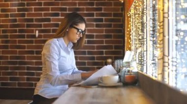 Bilgisayar dizüstü iş çalışmaları hakkında kullanarak kahve dükkanında çalışan genç güzel kadın