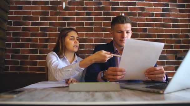 Kollegen arbeiten in einem Café und unterschreiben wichtige Dokumente — Stockvideo