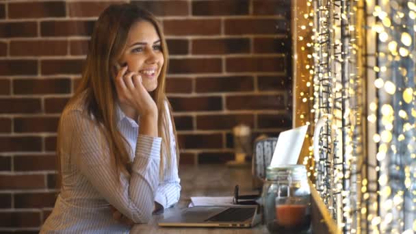 Alegre joven empresaria hablando por teléfono en un café — Vídeos de Stock