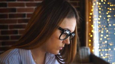 bir genç iş kadını bir kafede çalışır ve belgeler görünüyor