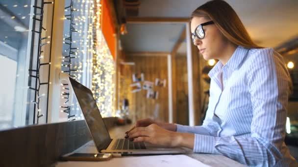 A empresária tira os óculos e acaba trabalhando em um laptop em um café — Vídeo de Stock