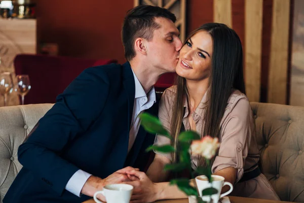 Un couple dîne dans un restaurant un homme embrasse une femme — Photo